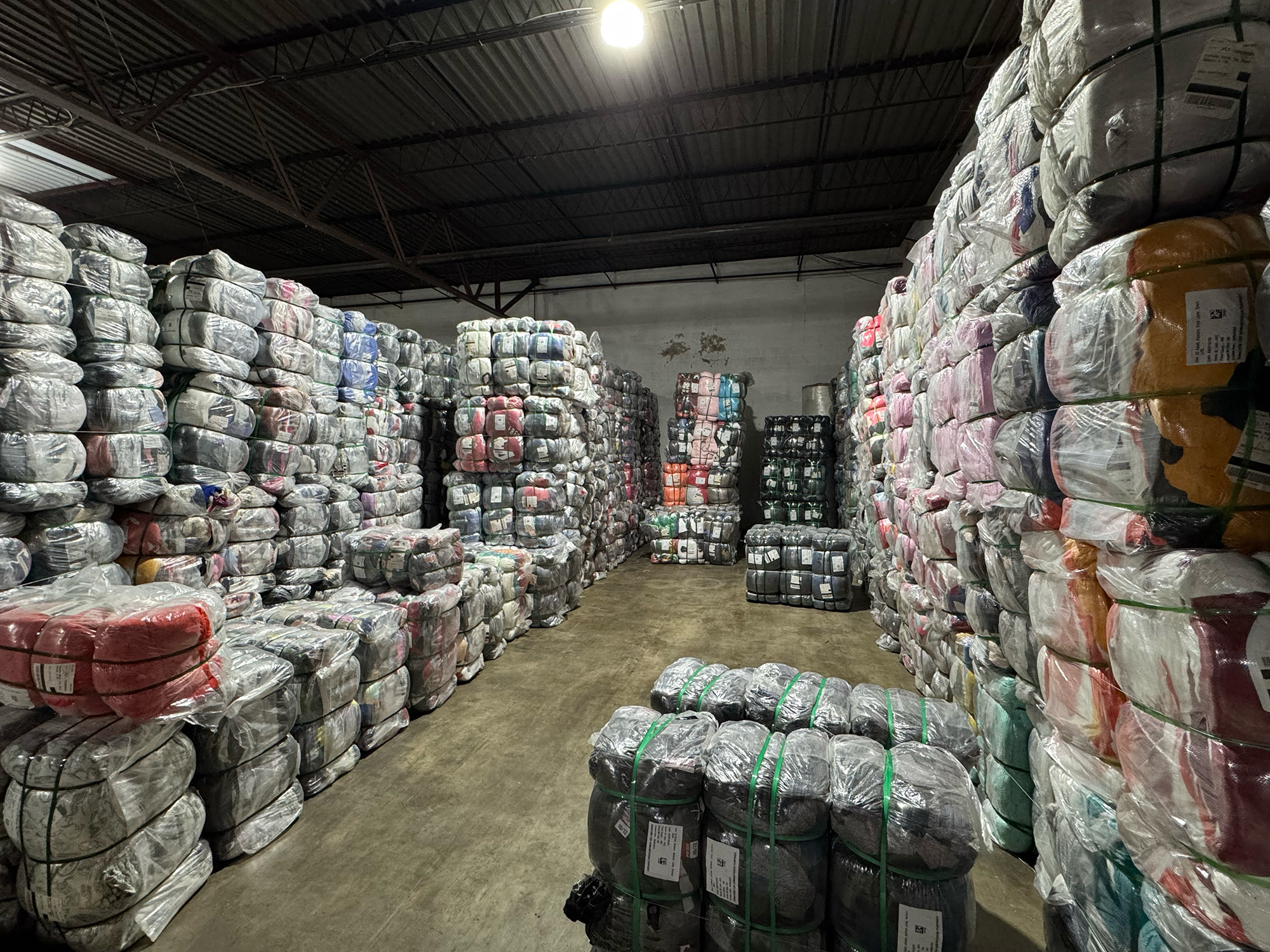 Wall of compressed apparel bales from retail liquidation programs