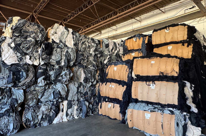 Bales of recycled denim and textile materials stacked in the Salvage Trading yard